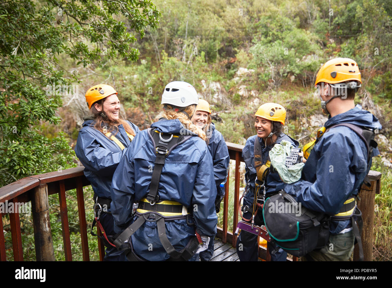 Gli amici di parlare, in attesa di una zip line nei boschi Foto Stock