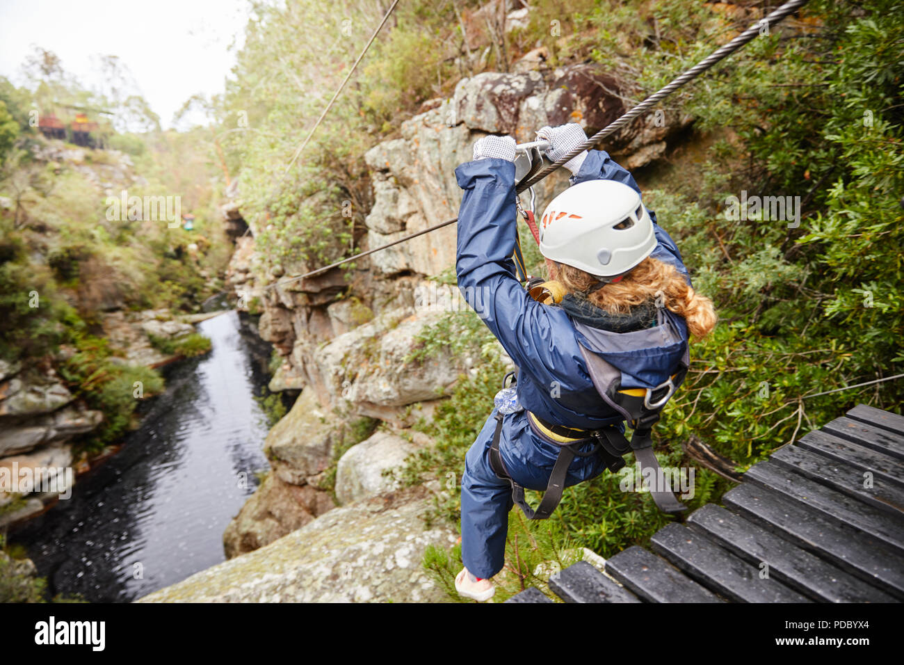 Donna fodera zip su stagno nel bosco Foto Stock