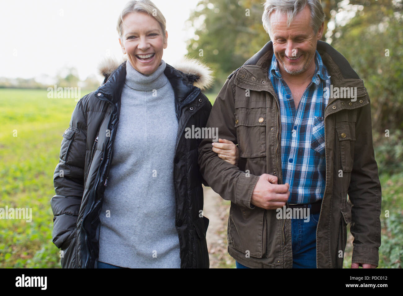 Felice Coppia matura camminando sotto braccio in posizione di parcheggio Foto Stock