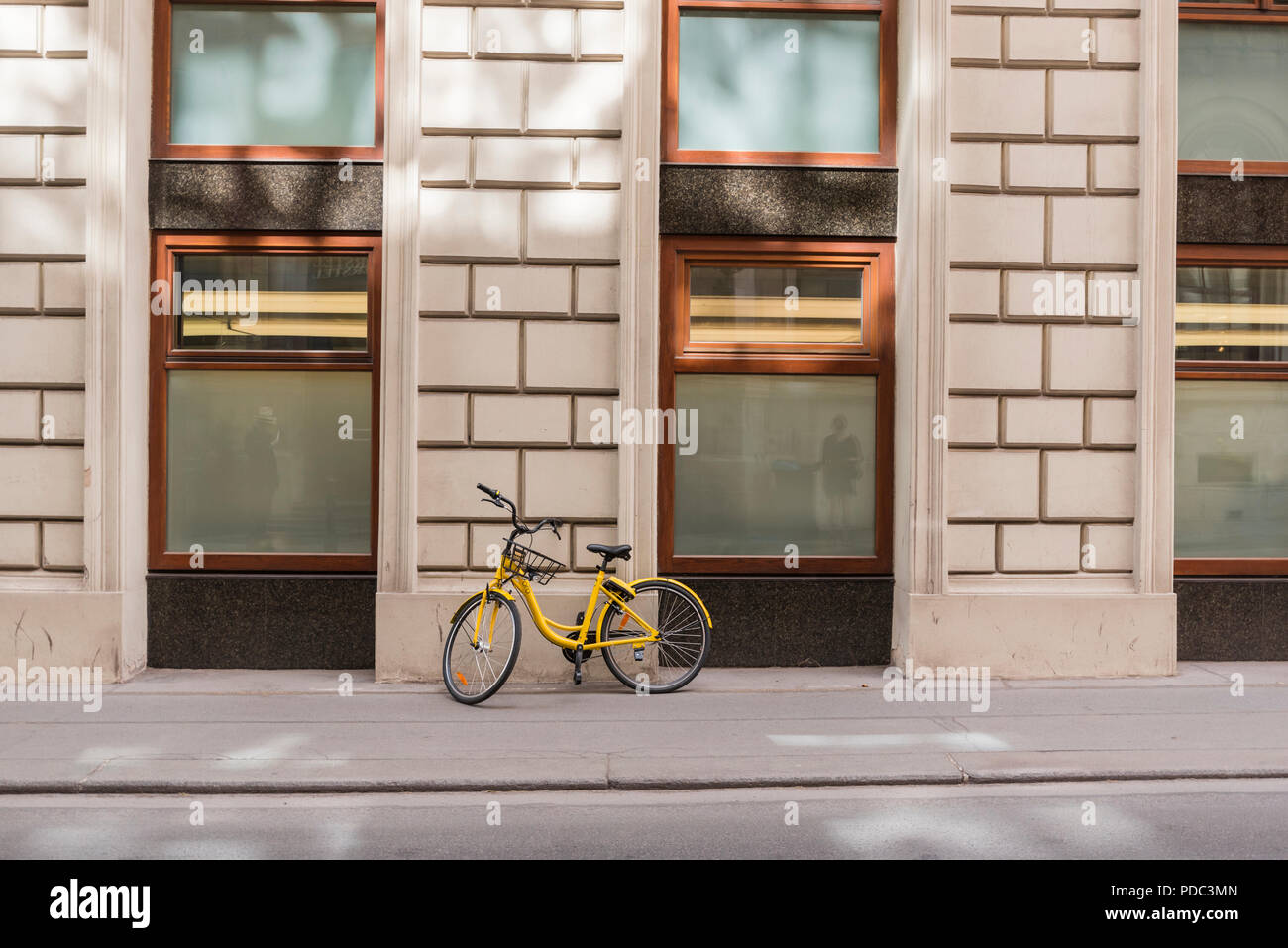 Giallo bicicletta su un marciapiede, Vienna, Austria Foto Stock