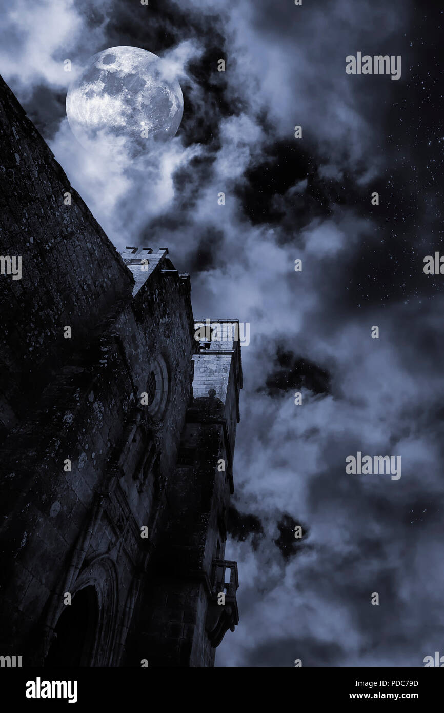 Chiesa medievale in una notte di luna piena con le nuvole e stelle Foto Stock