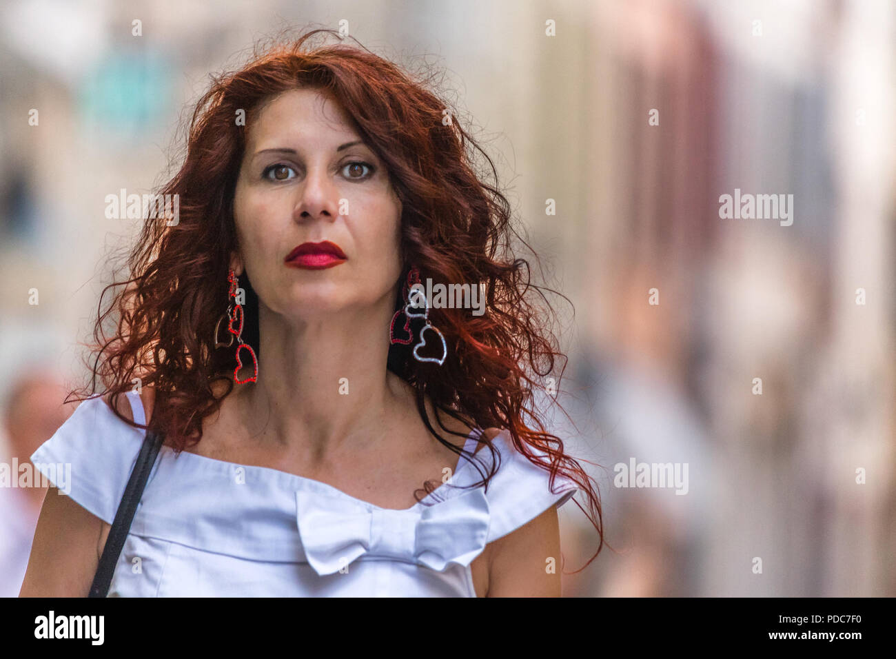 Grave e premurosa donna matura con rossetto rosso Foto Stock