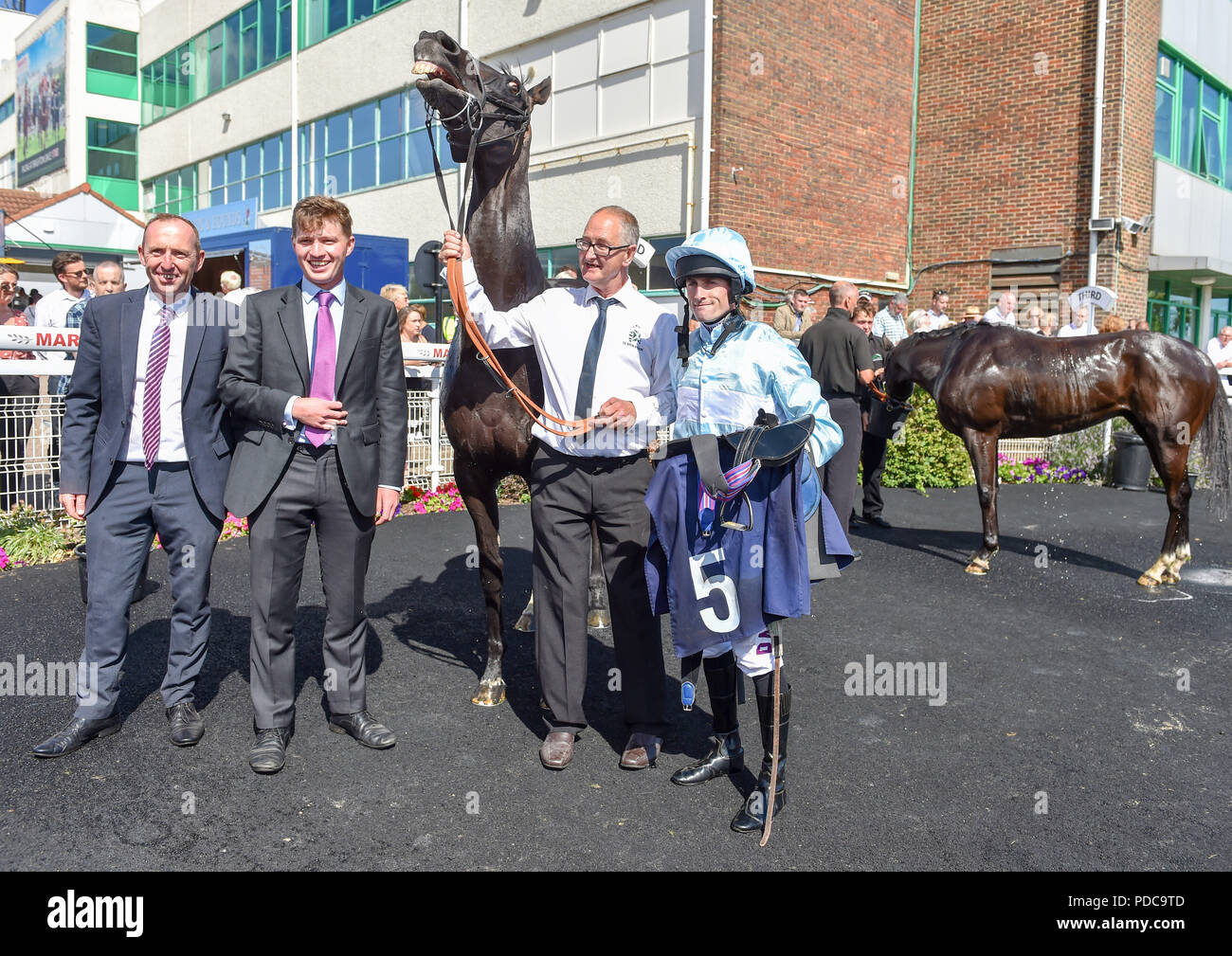 Brighton Regno Unito 8 Agosto 2018 - Lettore pastorale sembra essere ridere dopo essere cavalcato alla vittoria da fantino Charlie Bennett (a destra) il Bombardier Brighton Mile Challenge Trophy al Brighton gare Marathonbet festival di corse Marstons Giorno di apertura Credito: Simon Dack/Alamy Live News Foto Stock