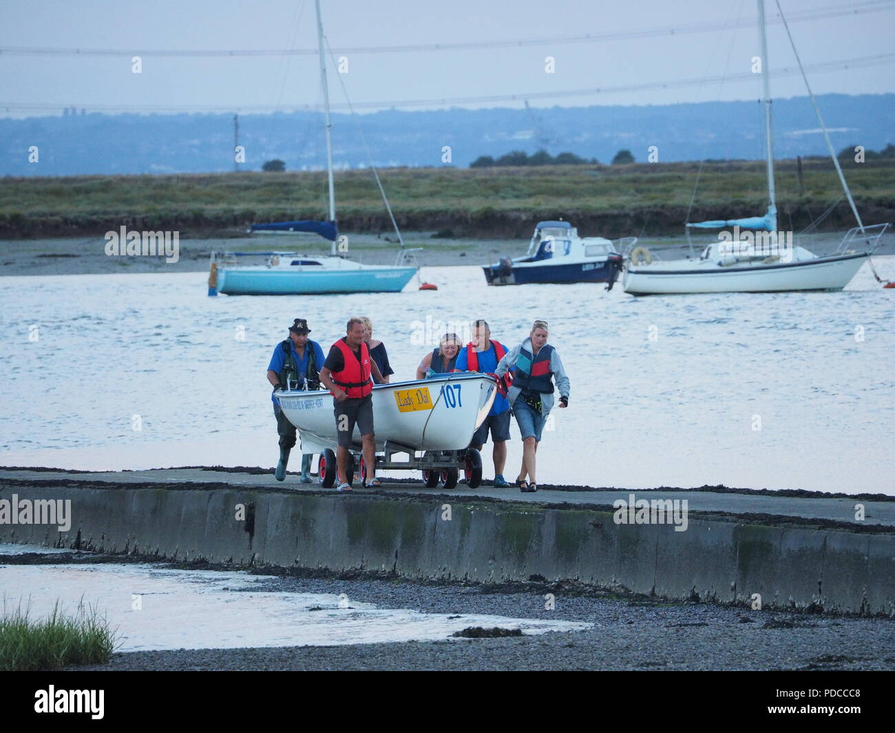 Queenborough, Kent, Regno Unito. 8 Ago, 2018. Regno Unito: Meteo tenui tramonto in Queenborough, Kent con un molto più freddo per sentire la sera aria, come vogatori da Queenborough Rowing Club vengono a riva. Credito: James Bell/Alamy Live News Foto Stock