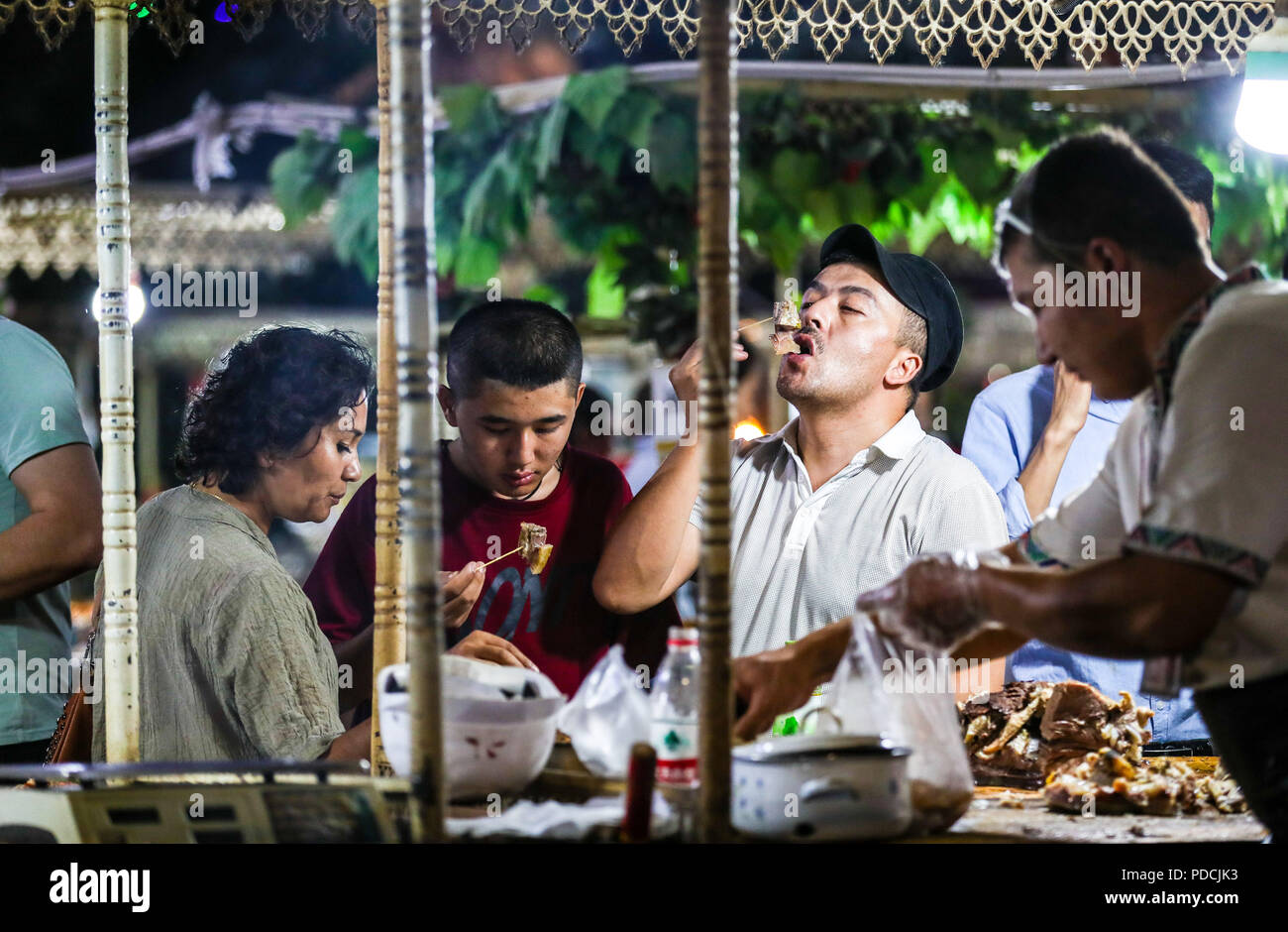 Urumqi, della Cina di Xinjiang Uygur Regione autonoma. Il 6 agosto, 2018. I residenti di gusto snack locali "carni bovine tendine' in una notte di mercato nella Città Vecchia di Kashgar, a nord-ovest della Cina di Xinjiang Uygur Regione autonoma, il 6 agosto 2018. Credito: Jiang Wenyao/Xinhua/Alamy Live News Foto Stock