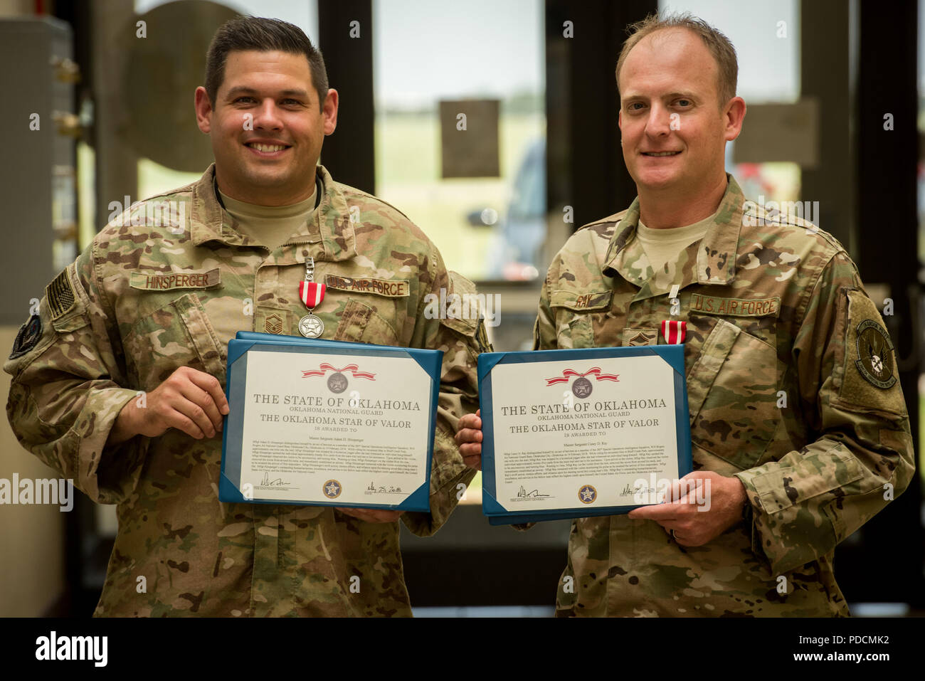 Master Sgt. Adam Hinsperger (sinistra), 285th Special Operations Intelligence Squadron (SOI) intelligence analyst, e Master Sgt. Casey Ray (medio), 285th SOIS intelligence analyst, rappresentano con la loro stella di Valor awards Agosto 4, 2018 a Will Rogers Air National Guard Base, Oklahoma CityThe due SOIS aviatori erano ciascuno assegnato il Oklahoma Star valorosi per le loro azioni per salvare un uomo da appendere dopo che essi entrarono nella scena dell'emergenza, mentre fuori la mountain bike in Oklahoma City nel febbraio 19, 2018. (U.S. Air National Guard photo by Staff Sgt. Brigette Waltermire) Foto Stock