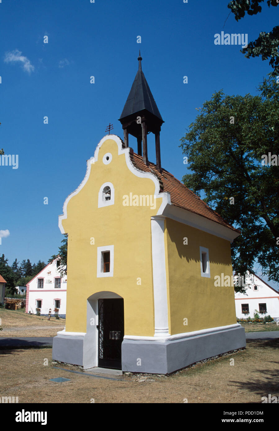 Ocra la cappella dipinta nello storico villaggio di Holasovice in Boemia del Sud nella Repubblica Ceca Foto Stock