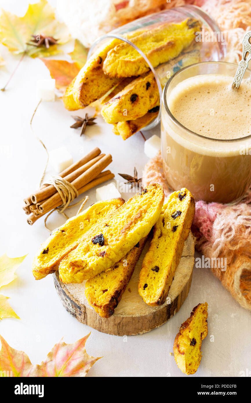 In autunno la cottura dello sfondo. Pane appena sfornato uvetta e cannella biscotti e una tazza di caffè cappuccino sulla lavagna luminosa o ardesia sfondo. Foto Stock