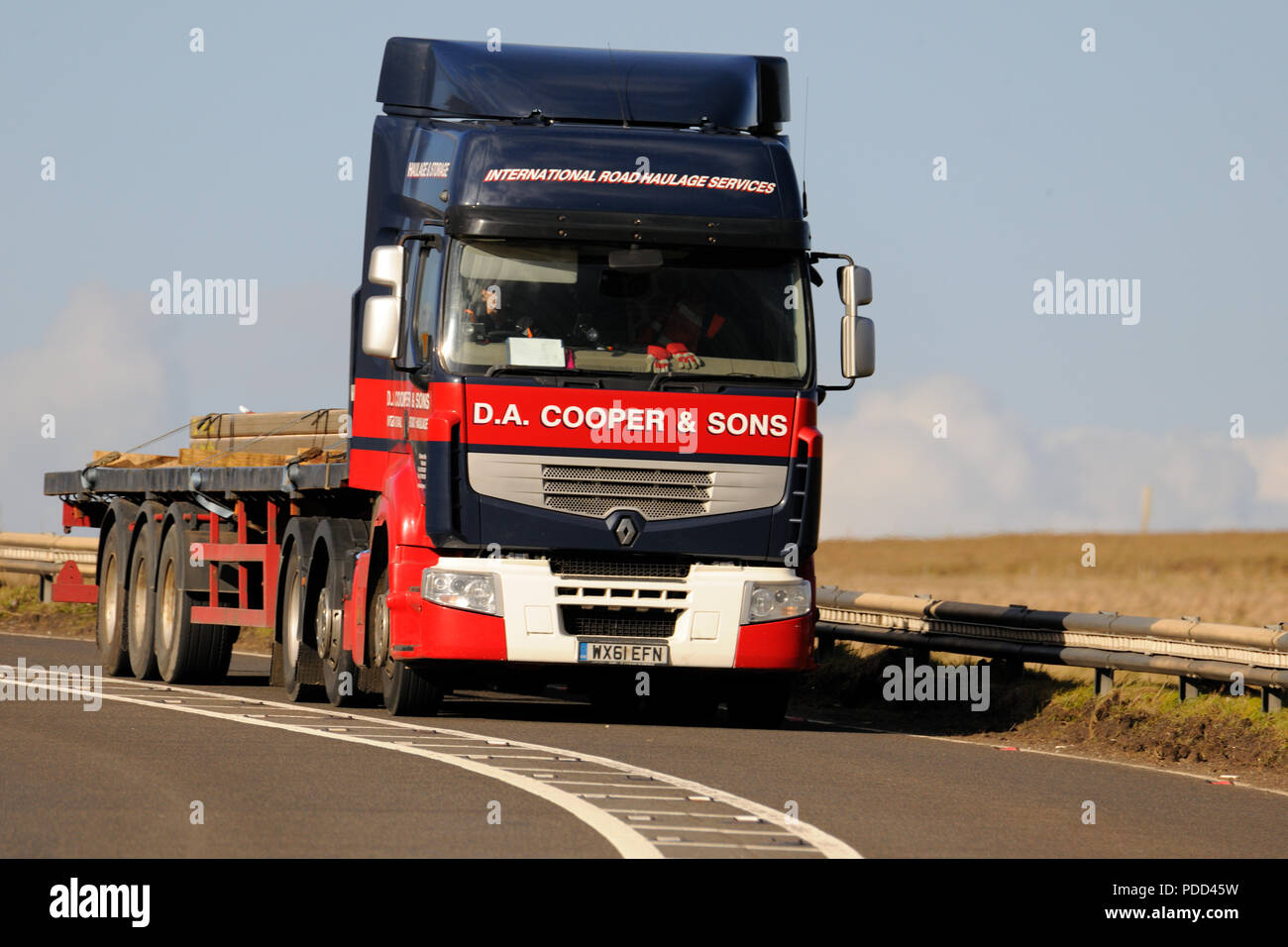 Renault camion con pianale rimorchio caricato con barre di acciaio Guidando sulla A628 Woodhead passano nello Yorkshire, Regno Unito Foto Stock