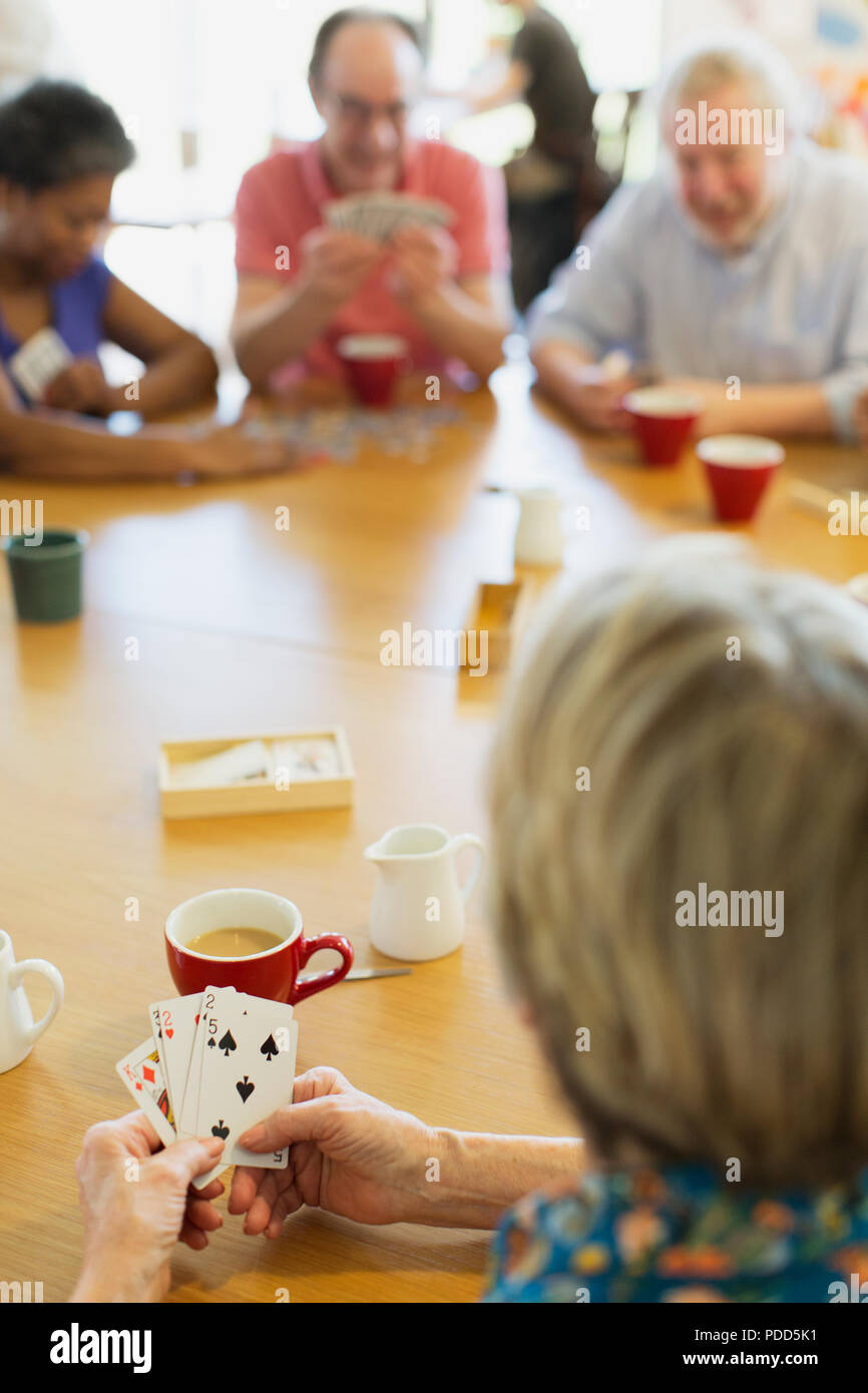 Senior amici giocando a carte in tavola nel centro comunitario Foto Stock