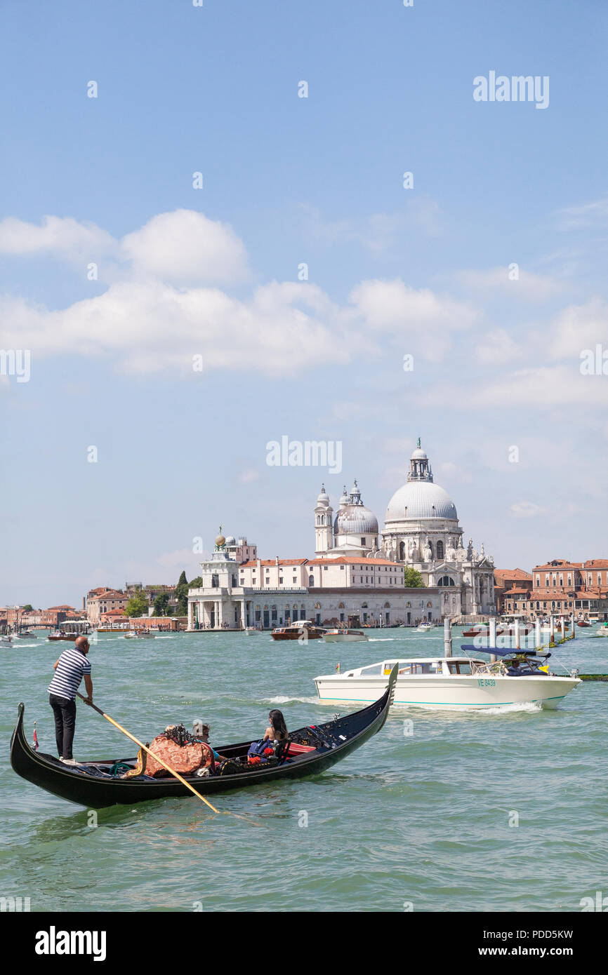 Gondole e taxi d'acqua in St Marks Basin, Venezia, Veneto, Italia davanti alla Basilica di Santa Maria della Salute e Punta della Dogana. Diversi per Foto Stock
