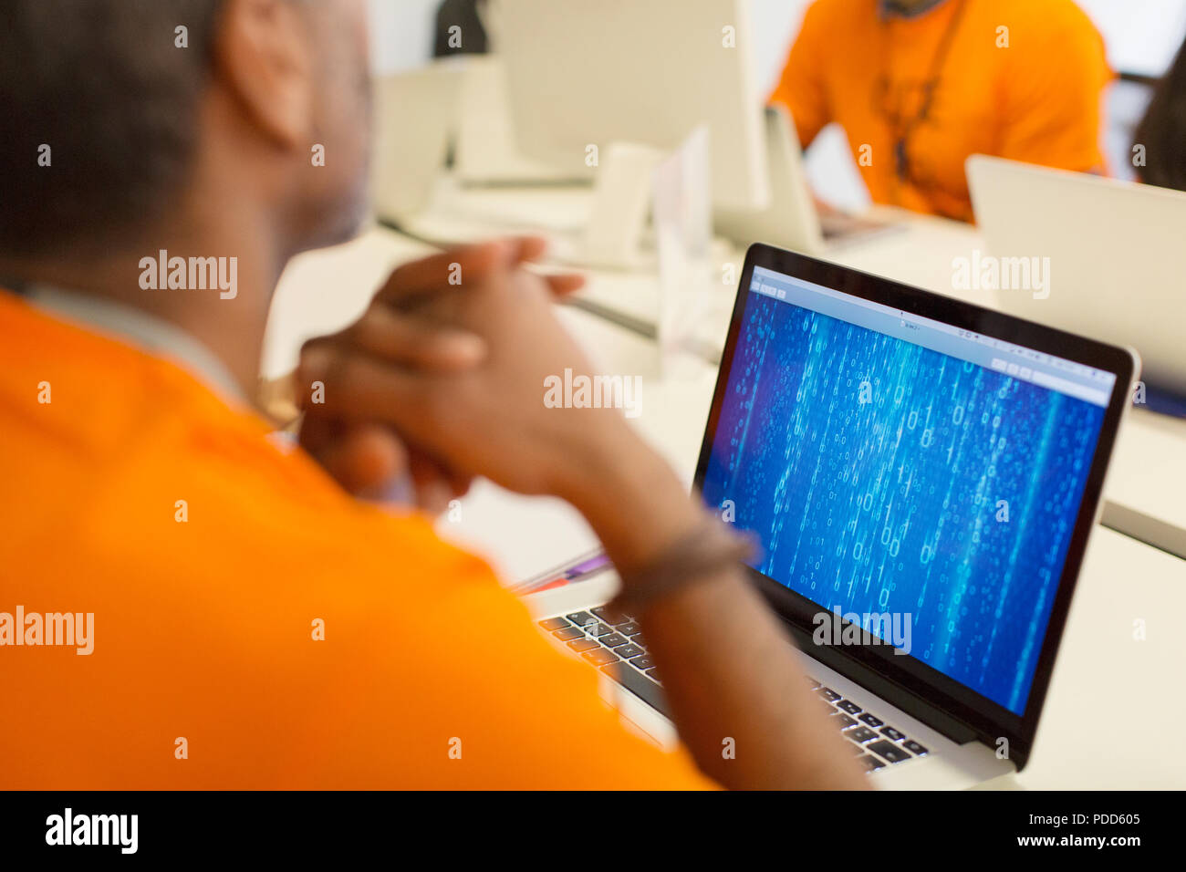 Hacker al laptop che codifica per la carità a hackathon Foto Stock