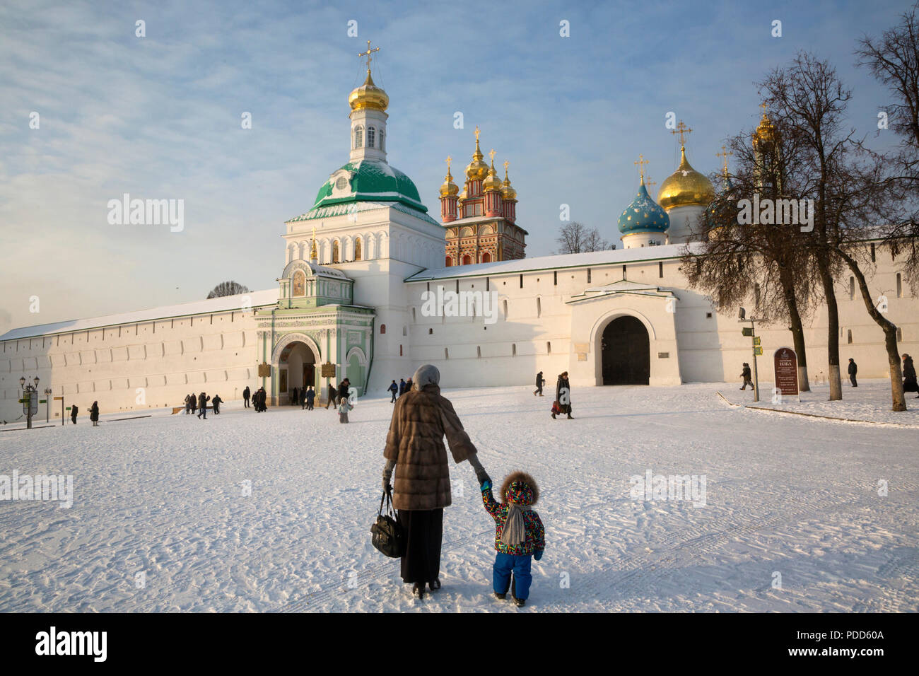 Una madre porta un bambino per il grande monastero della Trinità in Sergiyev Posad antica città russa, regione di Mosca, Russia Foto Stock