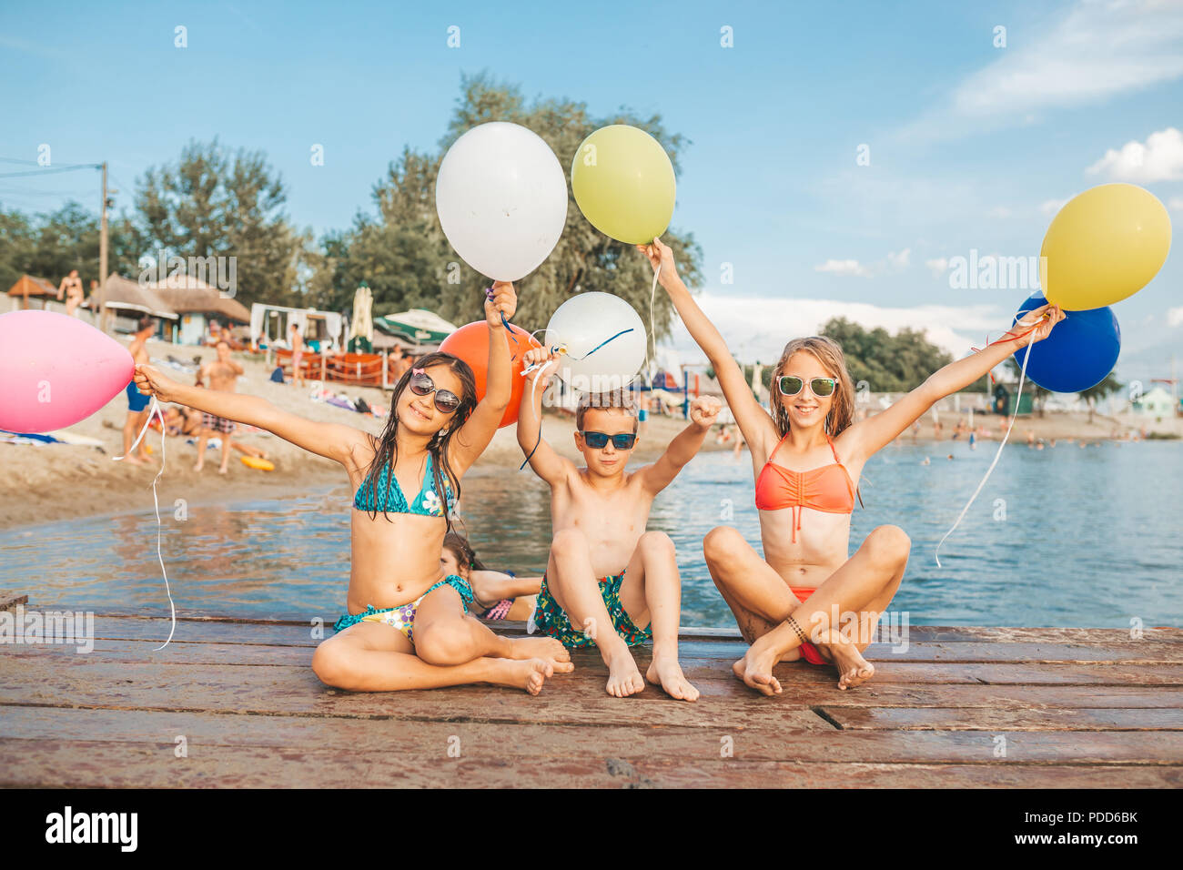Dei bambini felici giocando con palloncini in mare. Bambini il divertimento all'aperto. La vacanza estiva e uno stile di vita sano concetto Foto Stock