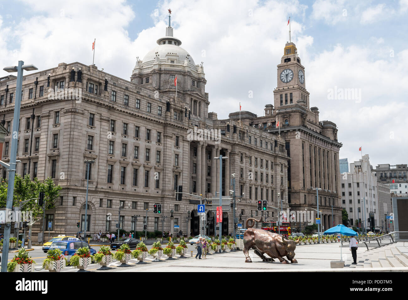 Edificio di riferimento e Bull statua (da Arturo di Modica) sul Bund a Shanghai in Cina. Persone, veicoli, messaggi pubblicitari e le sculture visibili Foto Stock