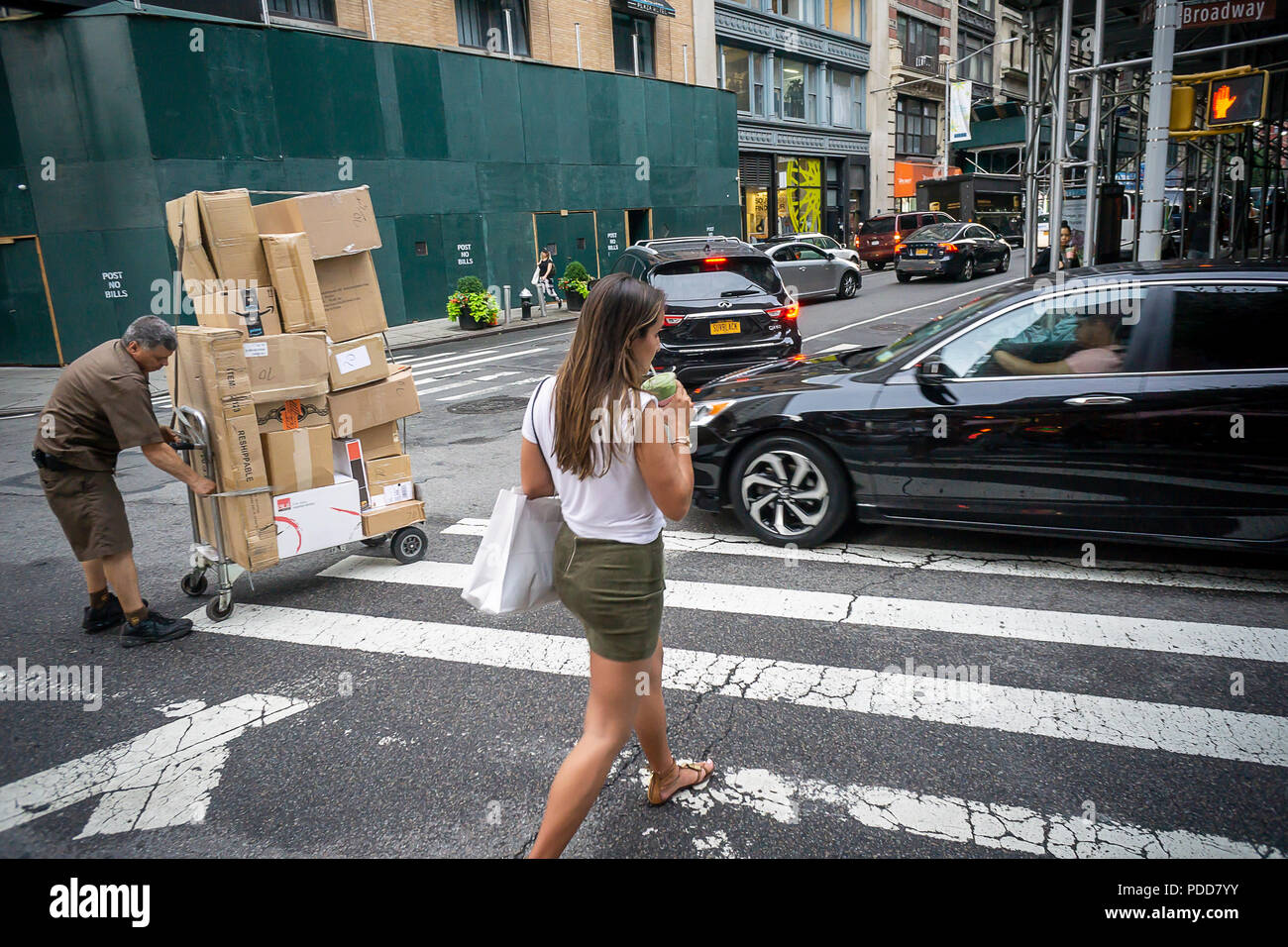 Una donna attraversa Broadway con la sua bevanda Matcha in NoMad quartiere di New York venerdì, 27 luglio 2018. La bevanda popolare, matcha, è terra di tè verde e viene utilizzato per rendere instagrammable bevande popolari con millennial. Caricato con antiossidanti matcha presumibilmente ha proprietà medicinali. (Â© Richard B. Levine) Foto Stock