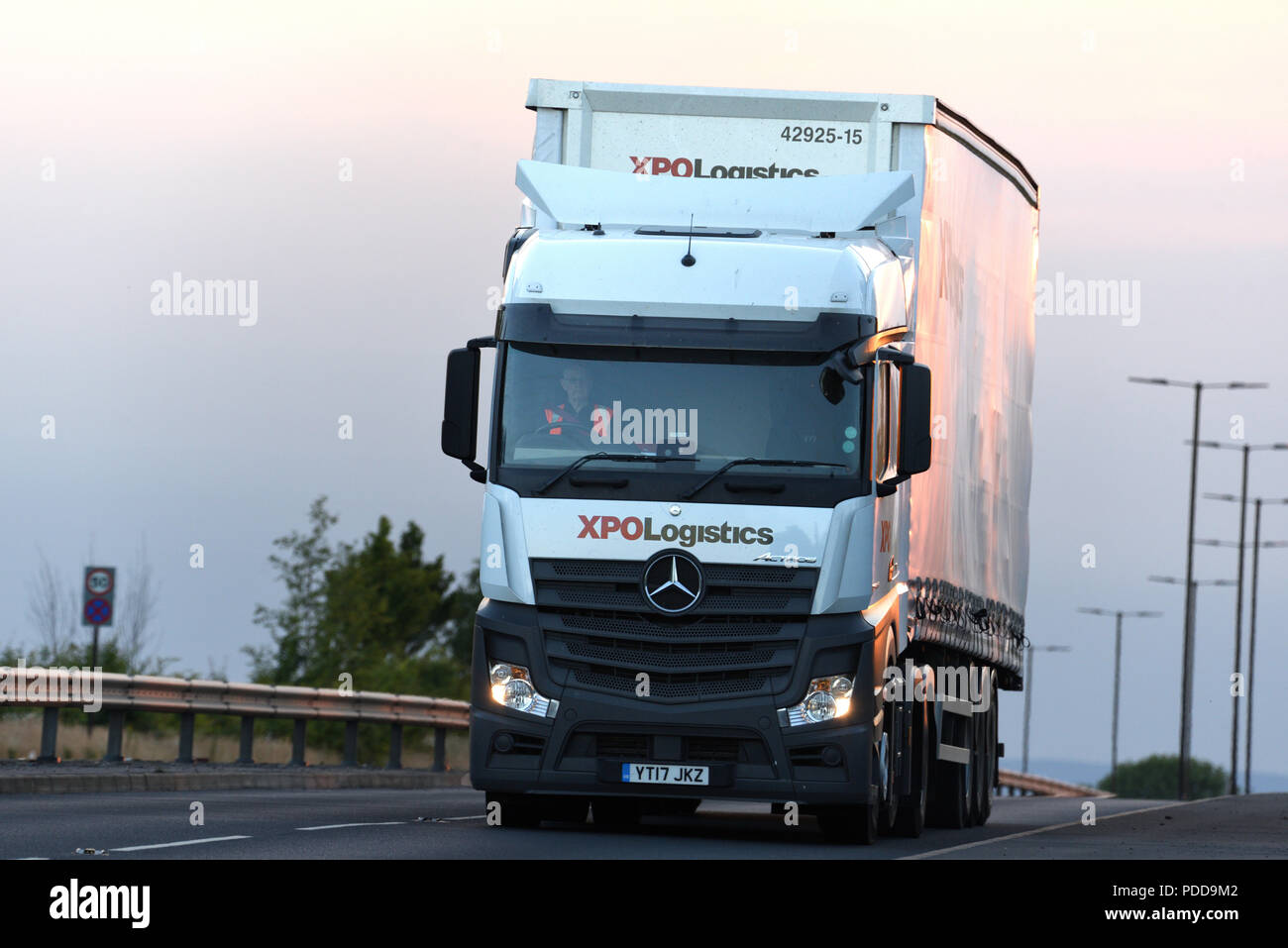 XPO Logistica Mercedes Actros carrello su una strada a doppia carreggiata al crepuscolo Foto Stock