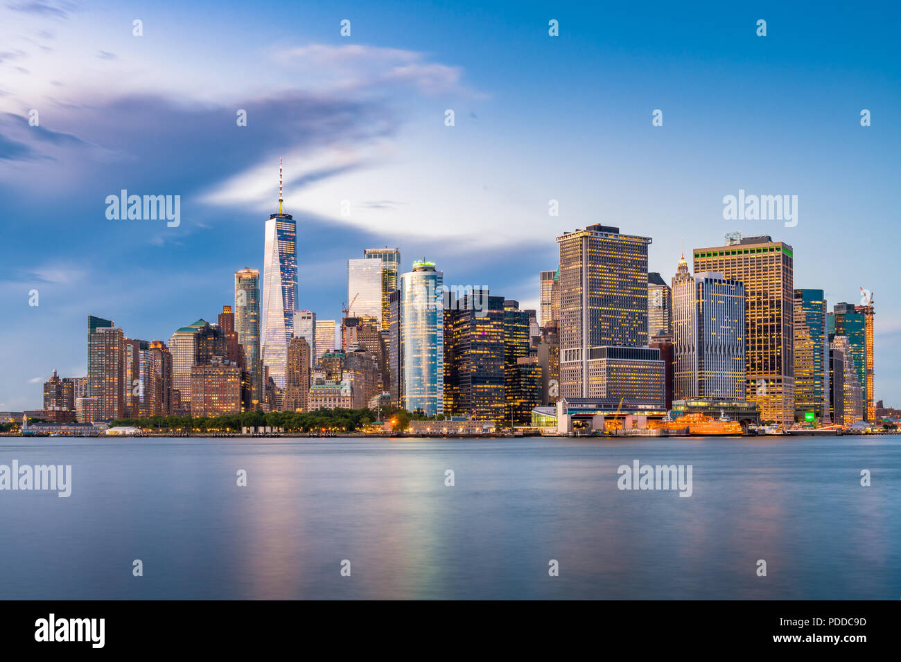 New York, New York, USA la parte inferiore di Manhattan Financial District skyline della città da tutto il porto di New York al crepuscolo. Foto Stock