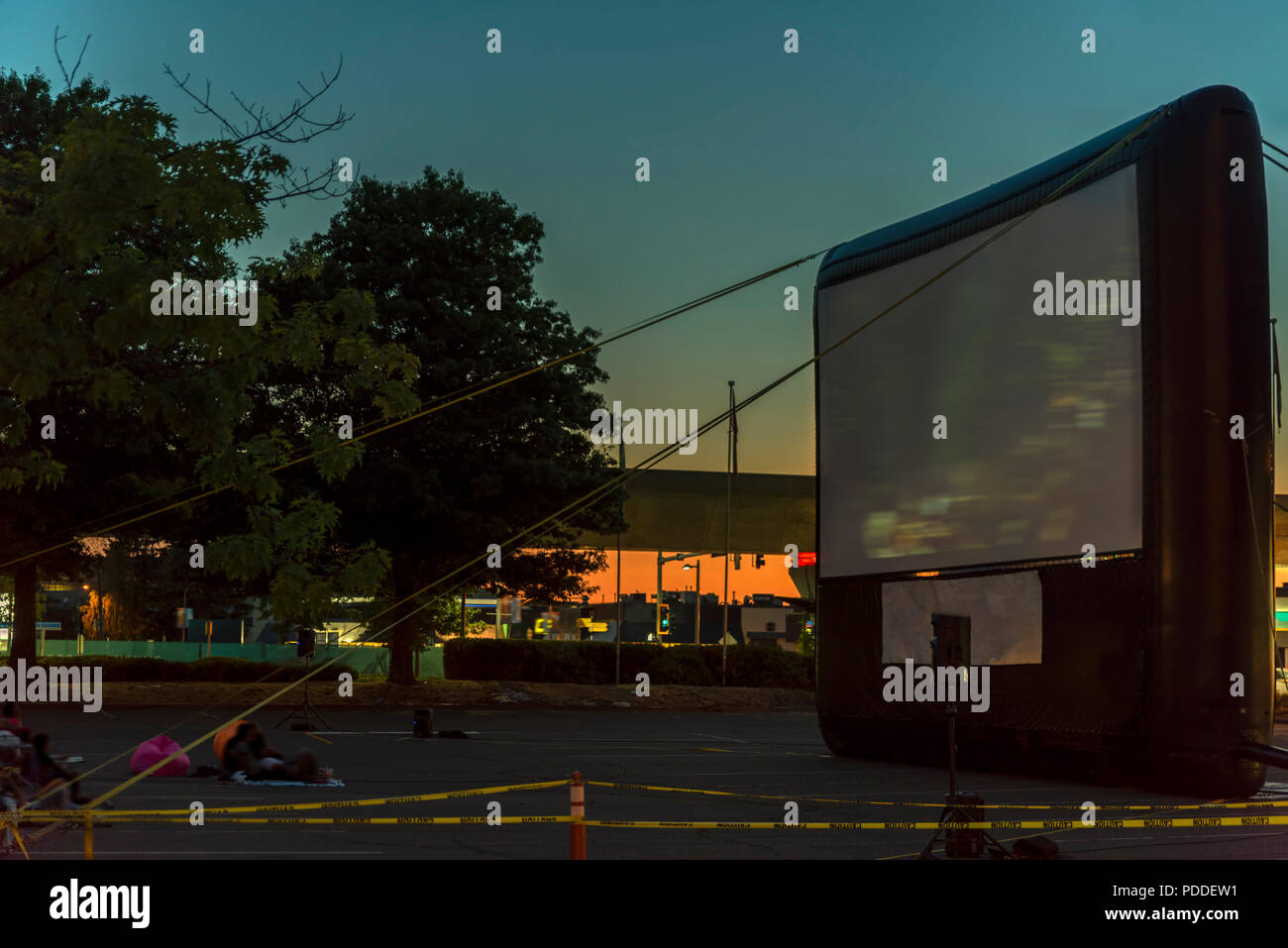 La visione dei film in aria aperta in un parcheggio nella città nella calda serata estiva Foto Stock