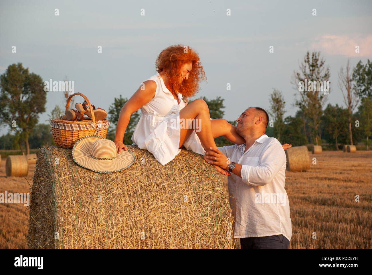 Data romantico su un taglio fresco campo nei pressi di un pagliaio Foto Stock