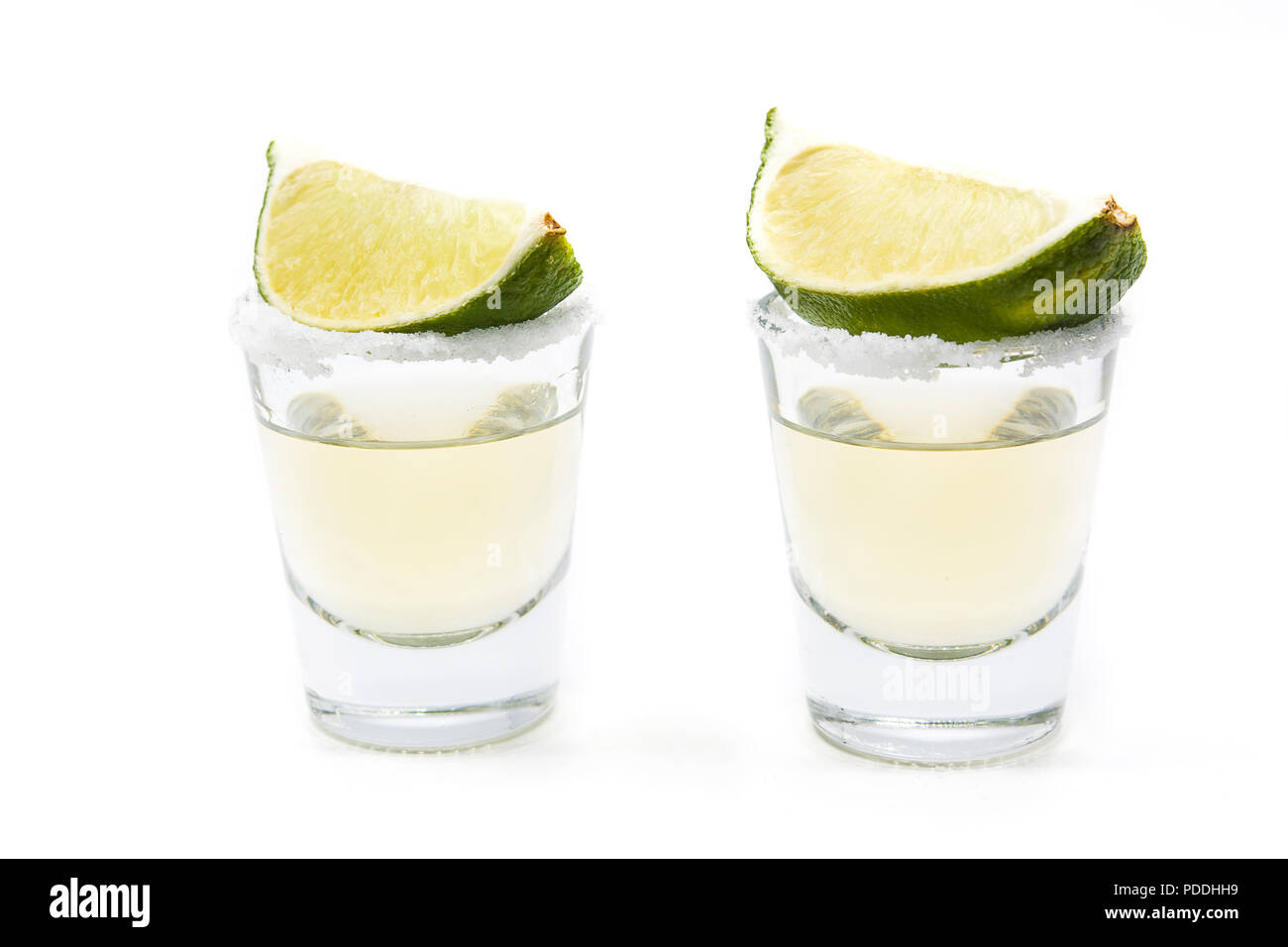 Mexican Gold tequila con calce e sale isolato su sfondo bianco. Foto Stock