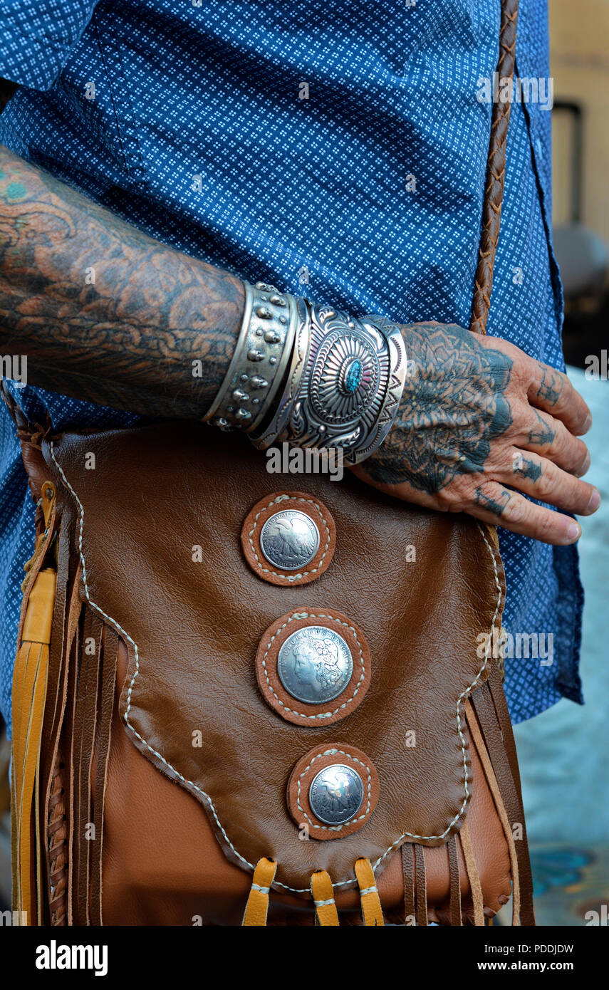 Un uomo con tatuaggi sulla sua mano e il braccio e indossando dei nativi  americani che porta gioielli fatti a mano una borsa in pelle Foto stock -  Alamy