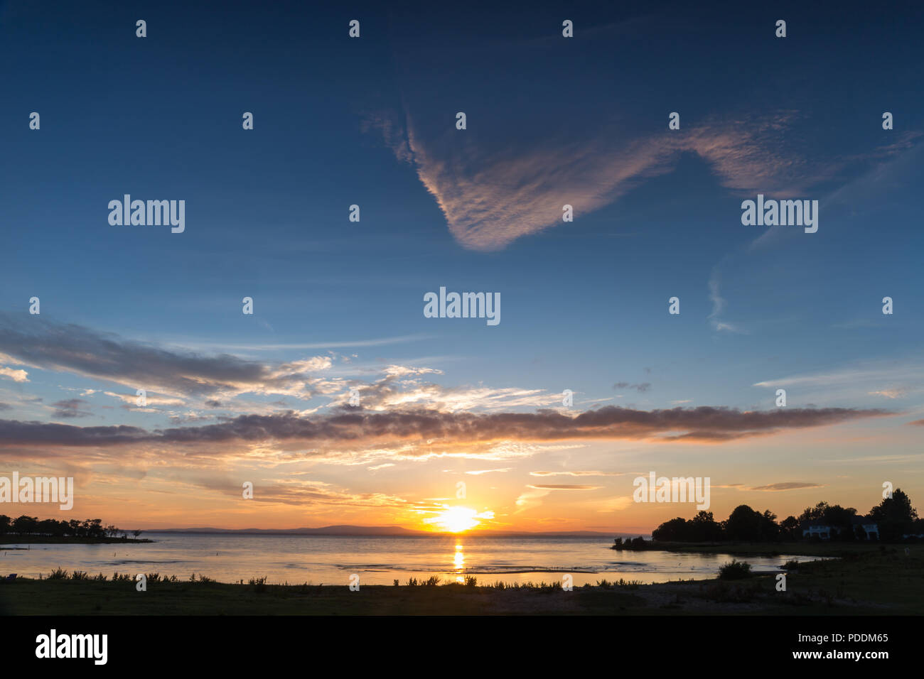 Un ampio bel tramonto e skyscape su un lago, Lough Neagh, N.Irlanda. Foto Stock