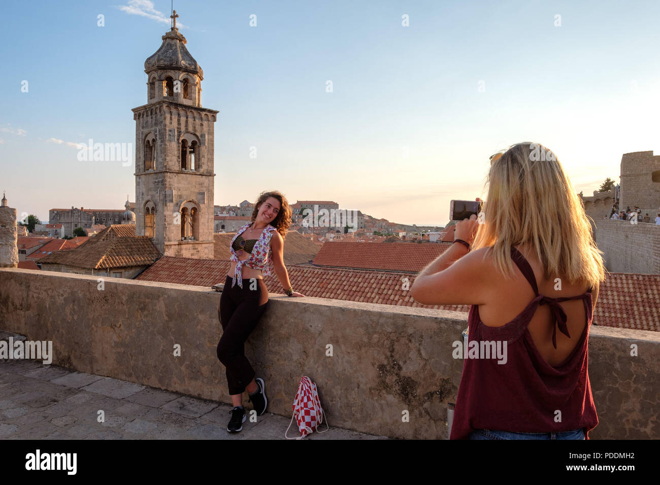 I turisti a scattare foto di un amico nella vecchia città di Dubrovnik con il suo smartphone Foto Stock