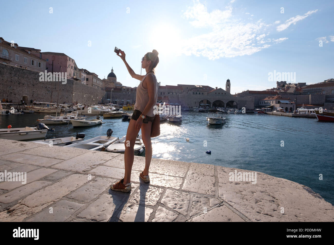 Turistica prendendo un selfie con il suo smartphone al porto di Dubrovnik, Croazia, Europa Foto Stock