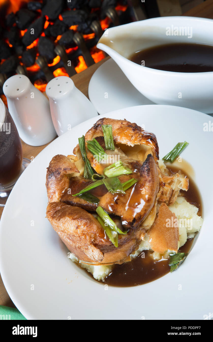Un pub inglese/ristorante piatto di rospo individuali nel foro su un letto di purea di patate servita con ricco marrone salsa gravy. Foto Stock