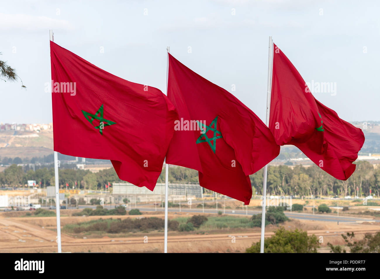 Tre marocchini bandiere nazionali battenti dai pali vicino alla Tour Hassan a Rabat Foto Stock