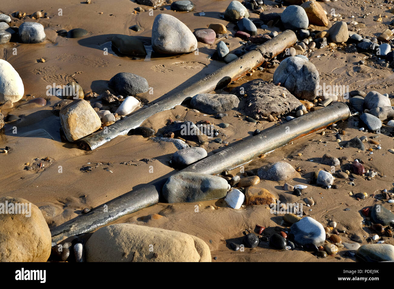 Resti della seconda guerra mondiale RP3 aerei inglesi da 3 pollici proiettili a razzo sulla spiaggia di Skipsea, UK. Un tempo di guerra poligono di tiro. Foto Stock