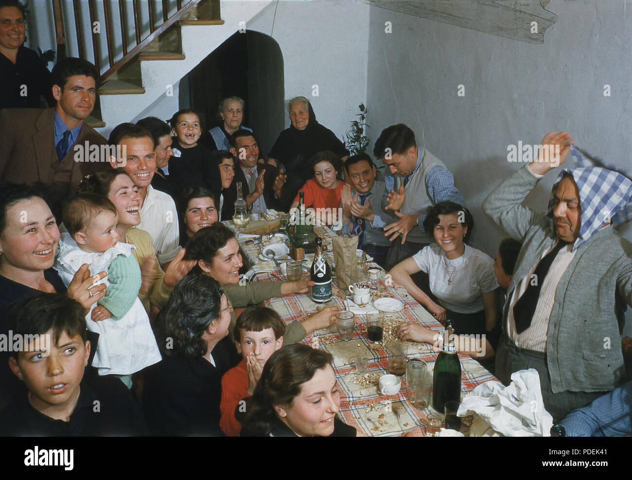 Anni sessanta, festa in famiglia, le diverse generazioni di una famiglia riuniscono togther attorno ad un lungo tavolo per celebrare una occasione speciale, Spagna. Foto Stock