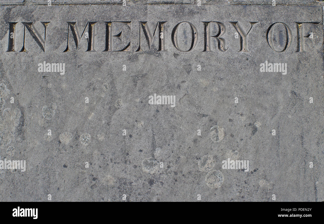 Un weathered monumento di pietra incisa con le parole - in memoria di - con lo spazio al di sotto del testo. Foto Stock