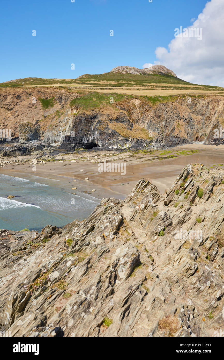 Rocce frastagliate baia accanto alla spiaggia di Whitesands in Pembrokeshire nel Galles del Sud su una soleggiata giornata chiara con il bianco puffy nuvole Foto Stock