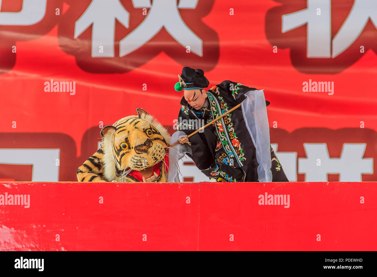 Xiamen, Cina - 14 settembre 2013: Puppeteer cinese che esegue uno spettacolo di marionette a mano su Wu Song uccidendo una tigre che mangia un uomo, antica storia cinese Foto Stock