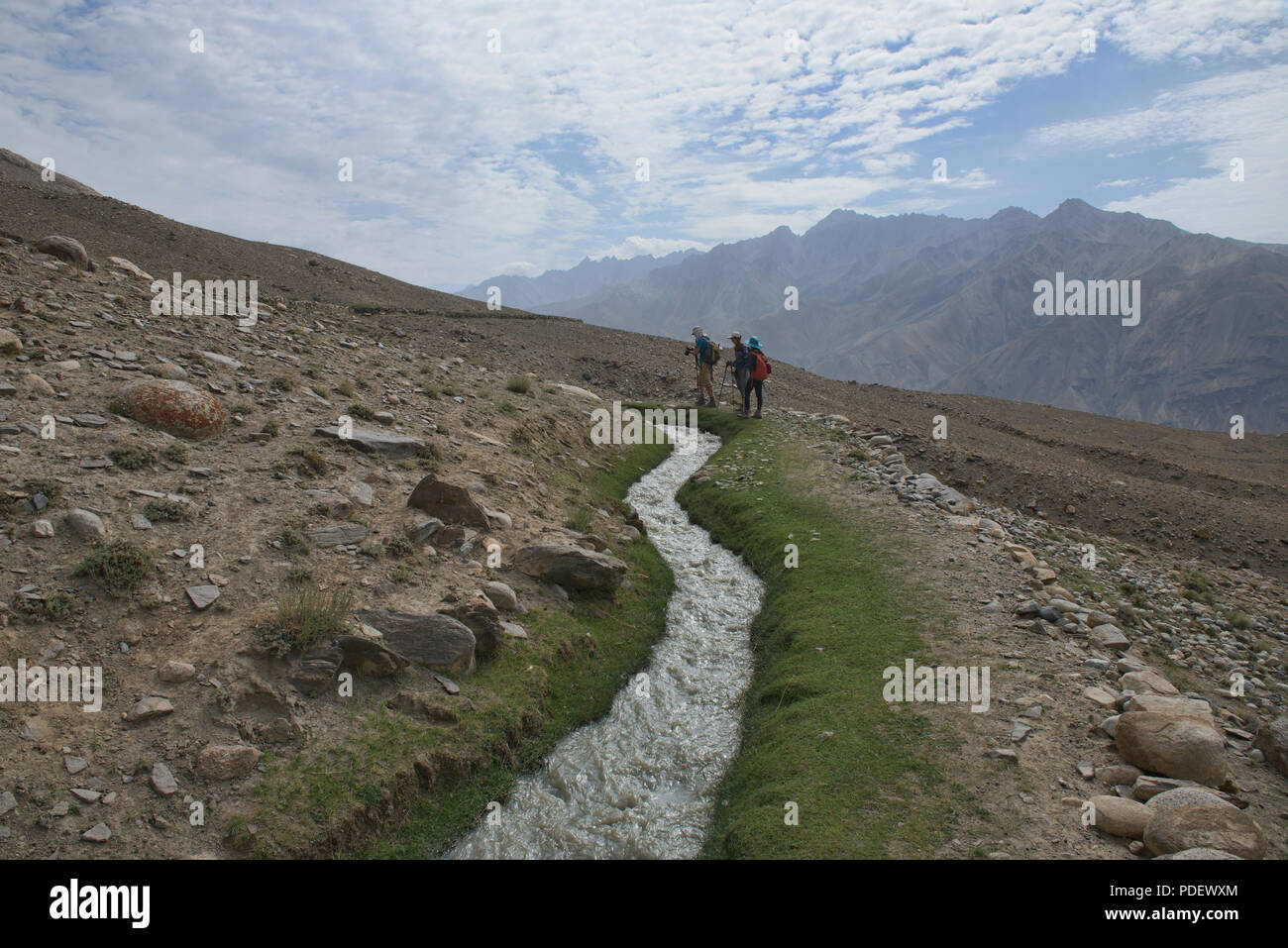 Trekking lungo un canale di irrigazione di Engel's Peak, Langar, Tagikistan Foto Stock