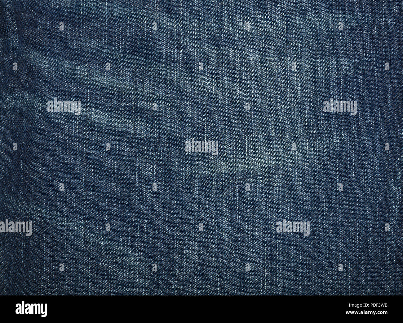 Dark indigo blue Cotone lavato jeans denim texture di sfondo usurata con macchie, close up Foto Stock