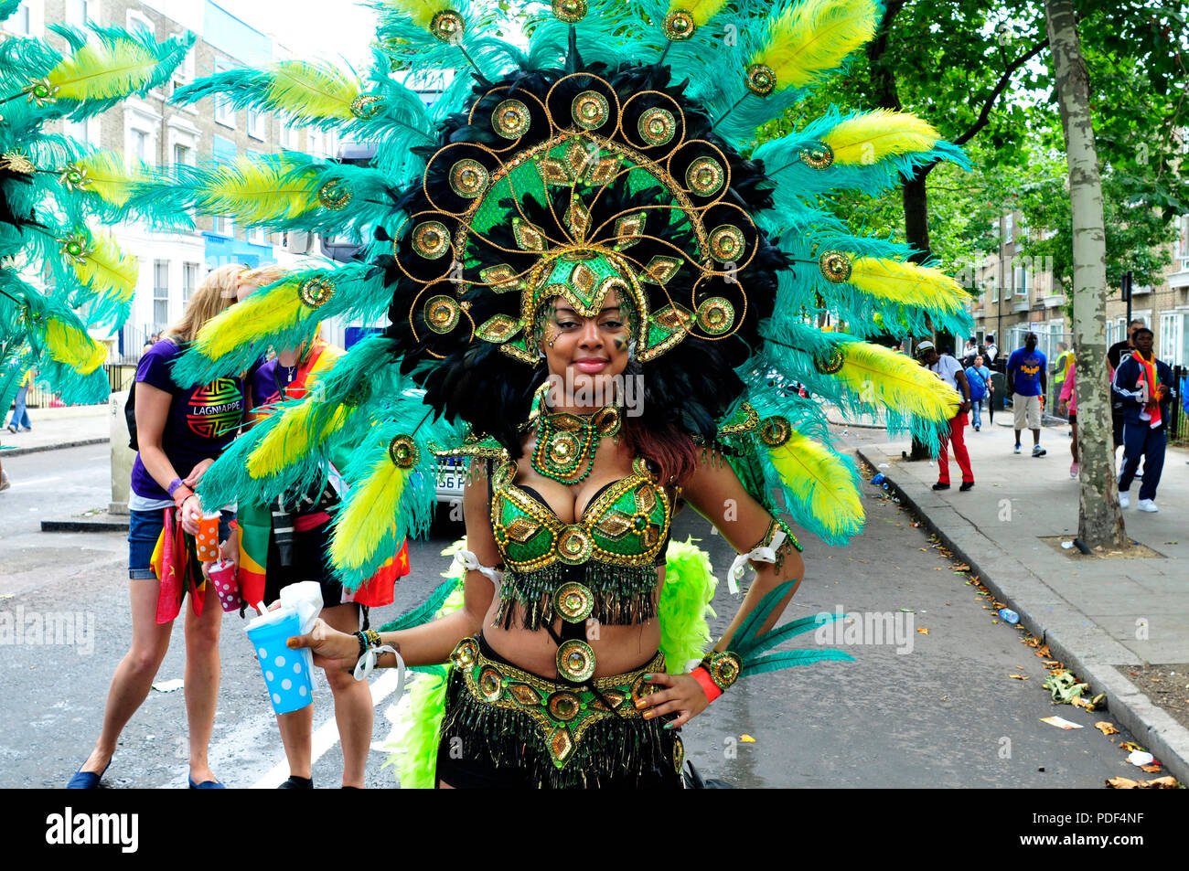 Una giovane donna in attesa di poter entrare a far parte delle prestazioni. Notting Hill Crnival. Londra, Regno Unito. Foto Stock