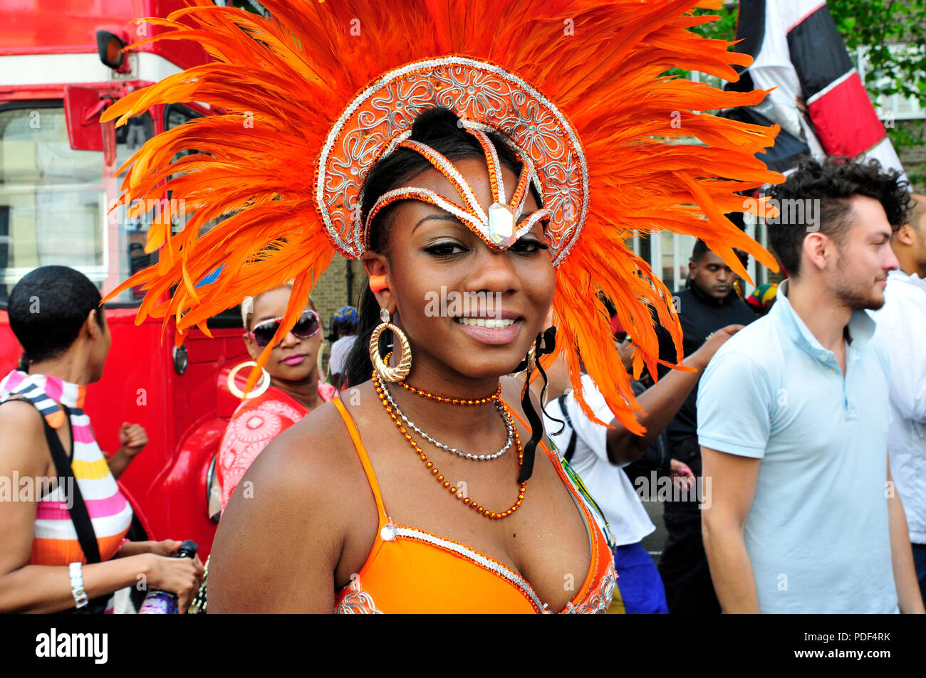 Una giovane donna con un costume colorato in attesa per le prestazioni di avvio. Nottinhg Hill Gate Carnevale. Londra, Regno Unito. Foto Stock