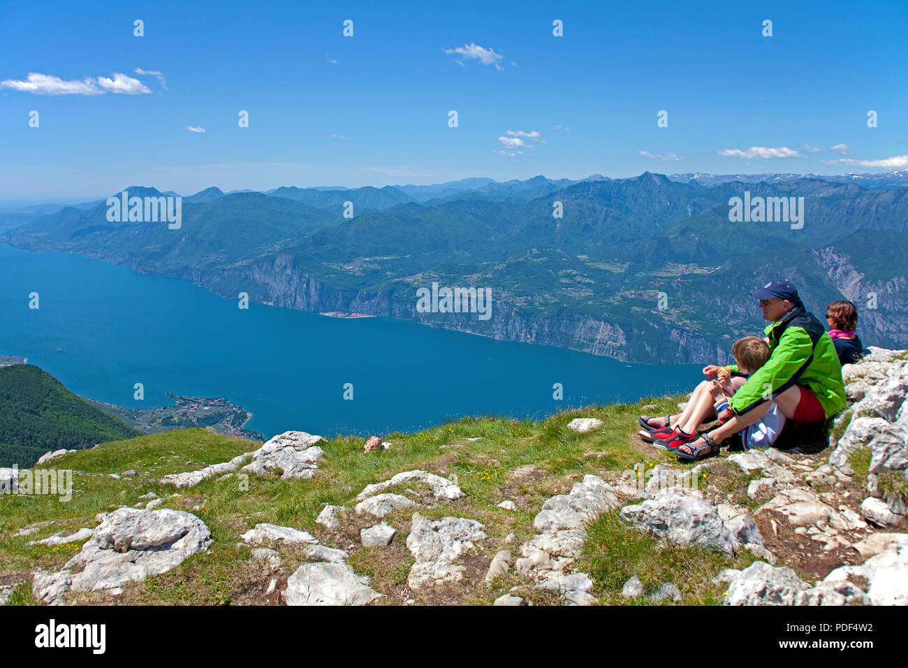 Escursionista godendo la vista dal Monte Baldo sul Lago di Garda, Malcesine, provincia di Verona, Lago di Garda, Lombardia, Italia Foto Stock