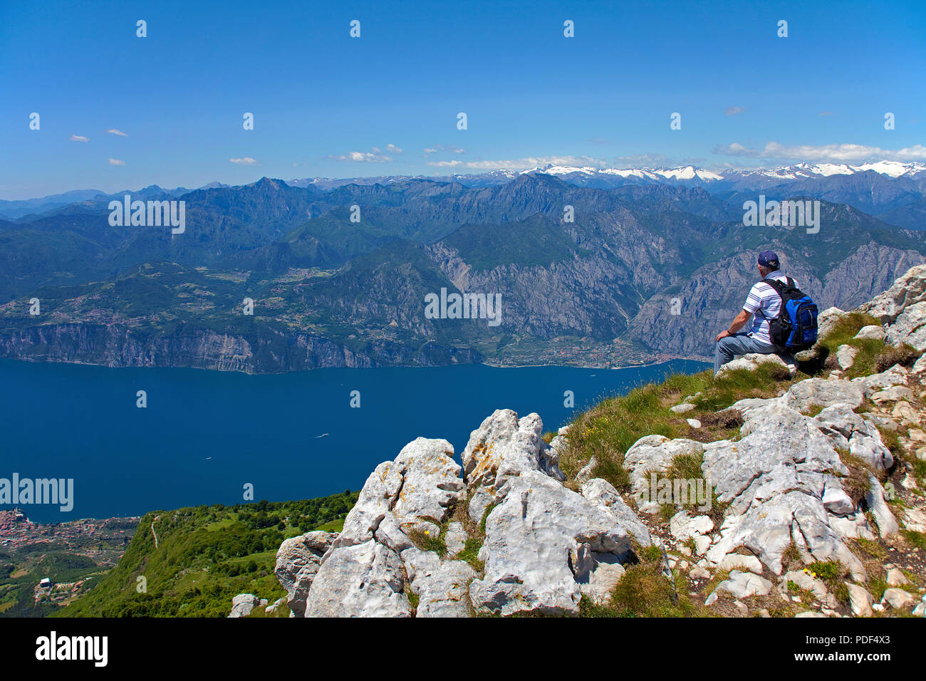 Escursionista godendo la vista dal Monte Baldo sul Lago di Garda, Malcesine, provincia di Verona, Lago di Garda, Lombardia, Italia Foto Stock