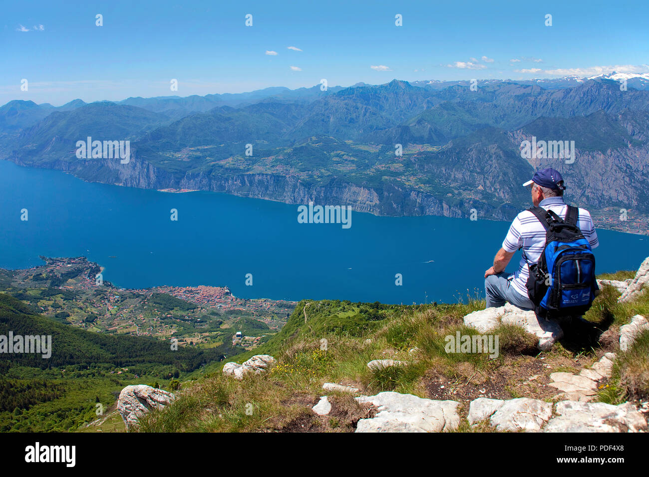 Escursionista godendo la vista dal Monte Baldo sul Lago di Garda, Malcesine, provincia di Verona, Lago di Garda, Lombardia, Italia Foto Stock