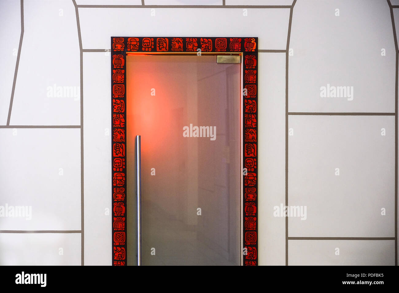 Frontiera e elementi di decorazione i modelli in bianco e nero e rosso. I più comuni segni etnici sono incorniciate da una porta. La parete è decorata nello stesso recinto Foto Stock