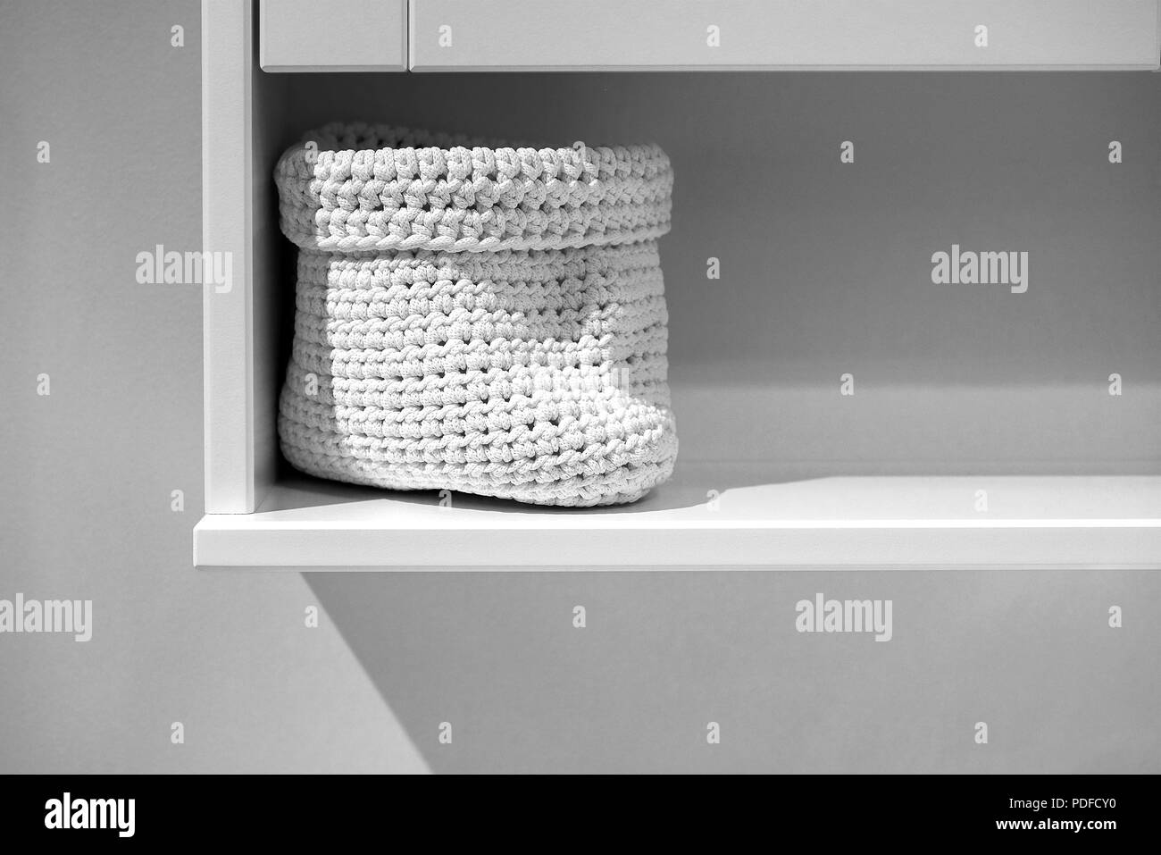 Asciugamani in rotolo con cesto in vimini su uno scaffale in background stand. Bagno design interno. Foto Stock