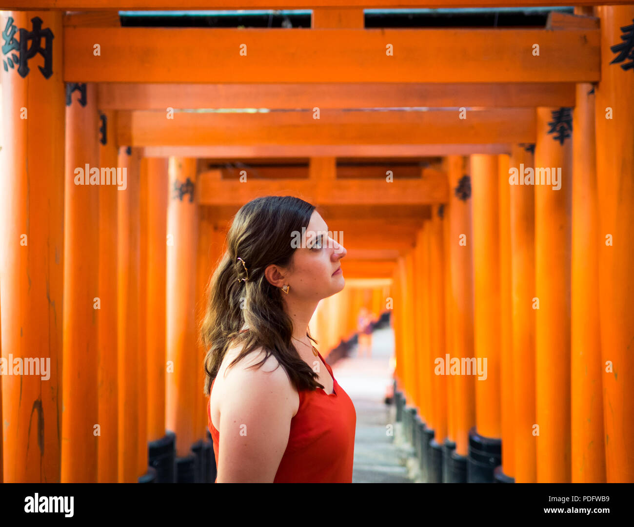 Una bella bruna ragazza a Vermiglio torii gates di Fushimi Inari-Taisha santuario (Fushimi Inari Taisha, Fushimi Inari santuario) vicino a Kyoto, Giappone. Foto Stock