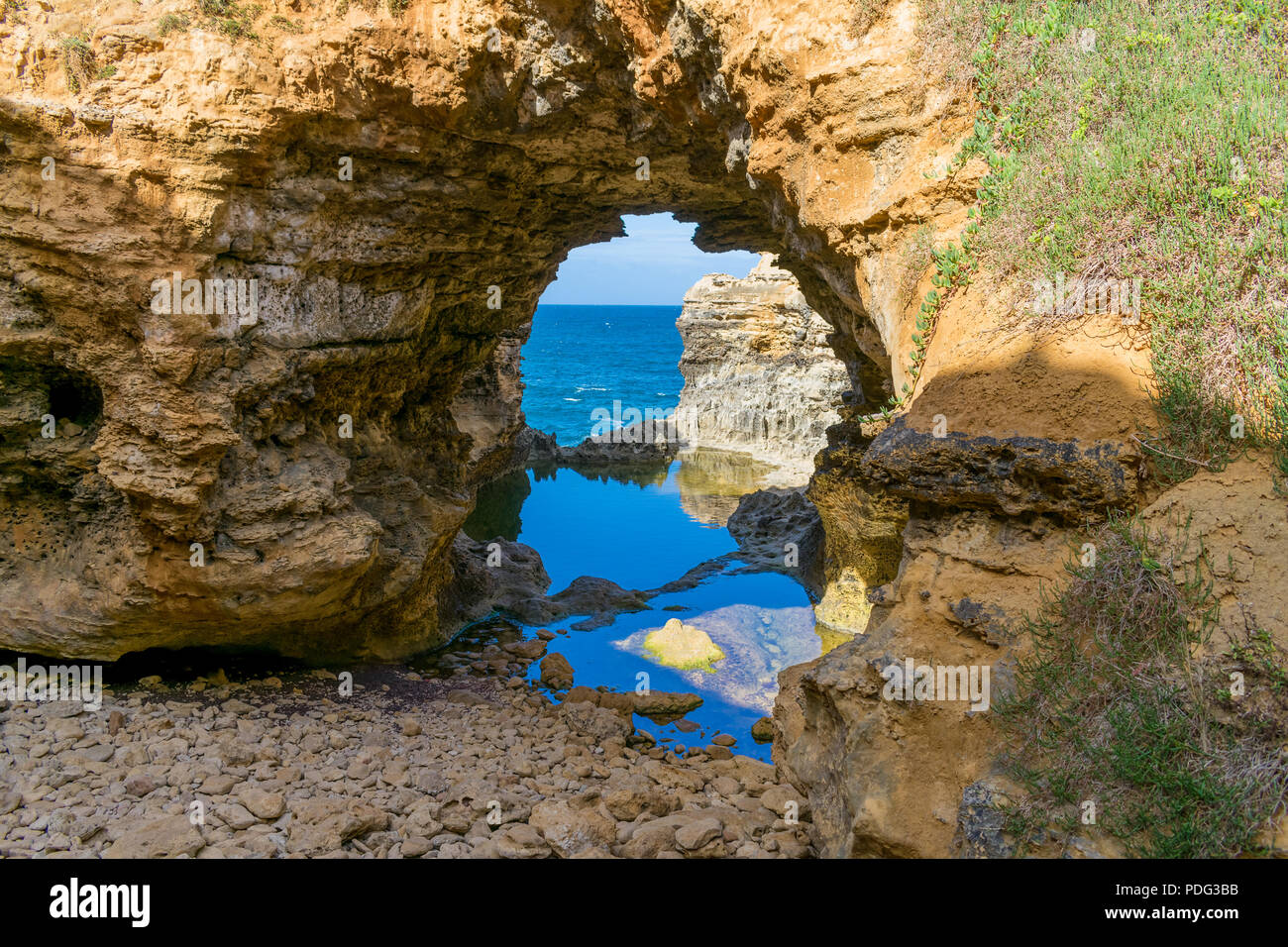 Foto della Grotta sulla Great Ocean Road con riflessione sull'acqua scattata durante l'estate Foto Stock