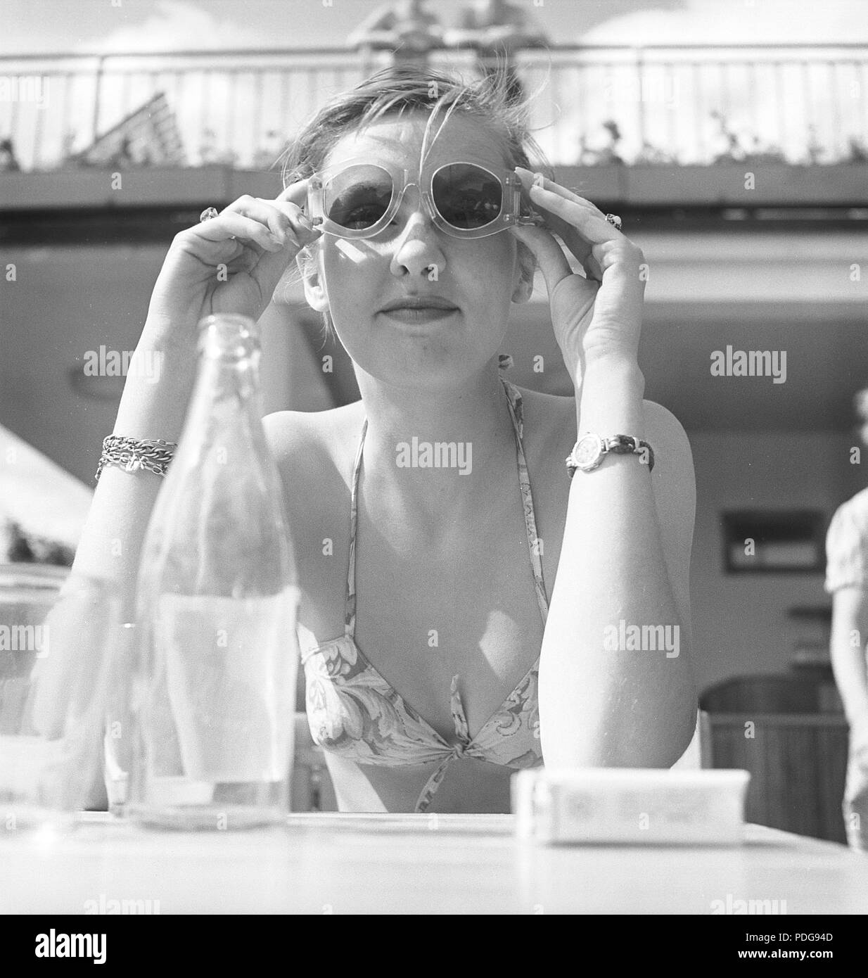 1950 Occhiali da sole. Una giovane donna in un giorno di estate è di provare i suoi occhiali da sole. 1950s. Foto Kristoffersson/AZ47-4 Foto Stock