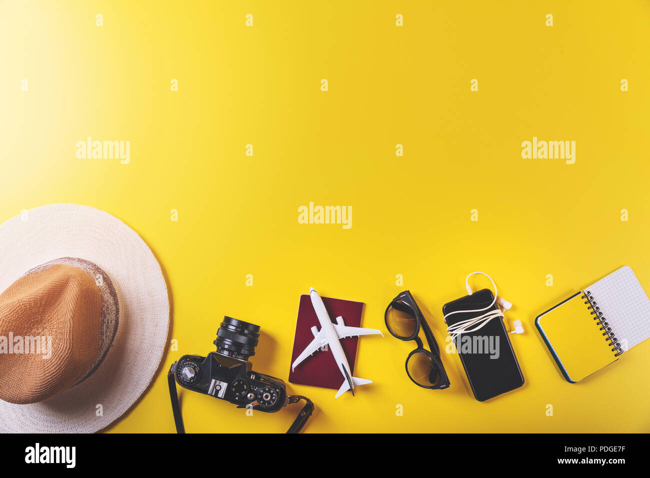 Accessori da viaggio su sfondo giallo con spazio di copia Foto Stock