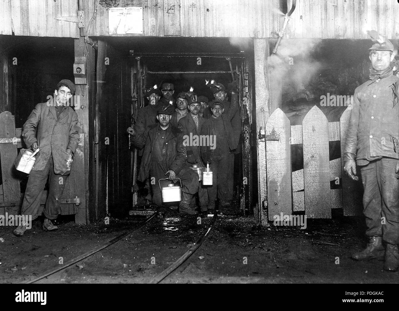 Al termine della giornata. Attesa per la gabbia per andare verso l'alto. La gabbia è completamente aperta su due lati e non molto ben protetti su altri due, e di solito è affollata come questo, Gennaio 1911 Foto Stock